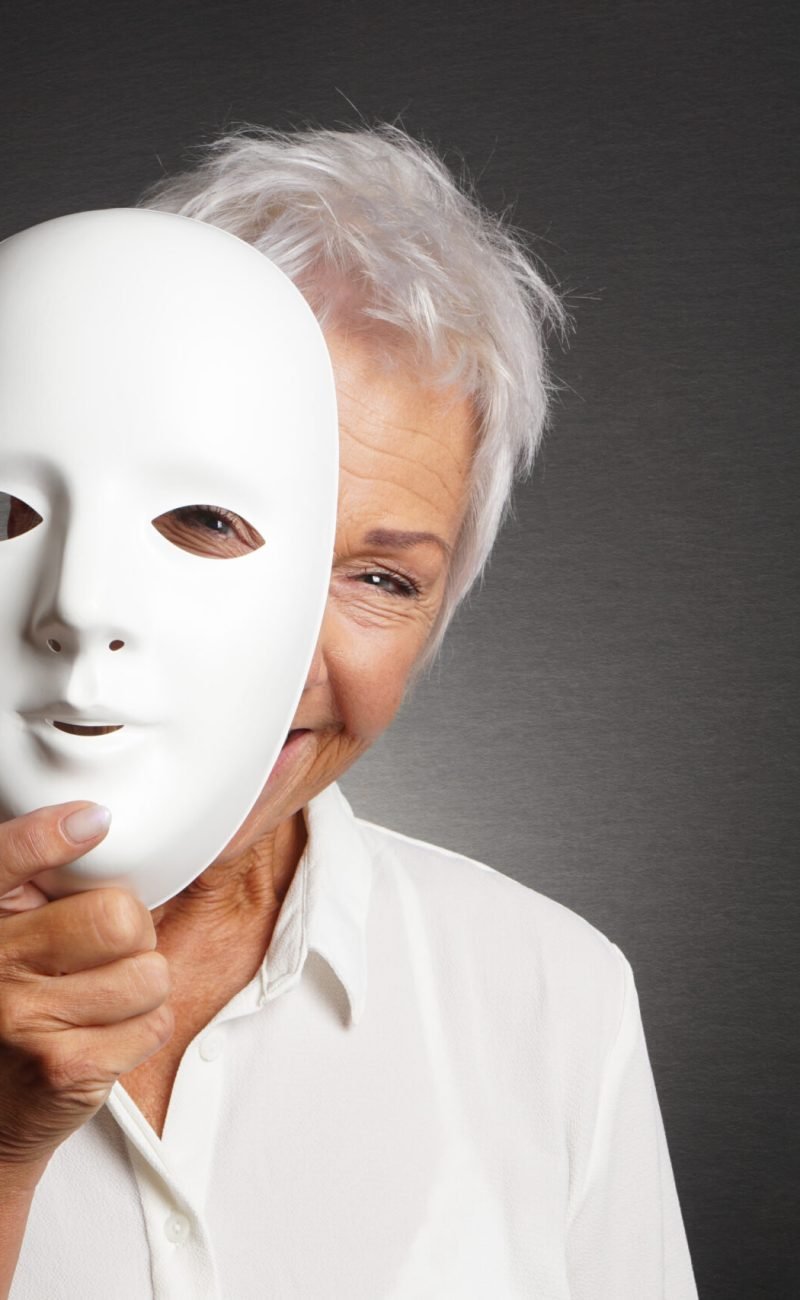 happy smiling laughing senior woman peeking from behind mask