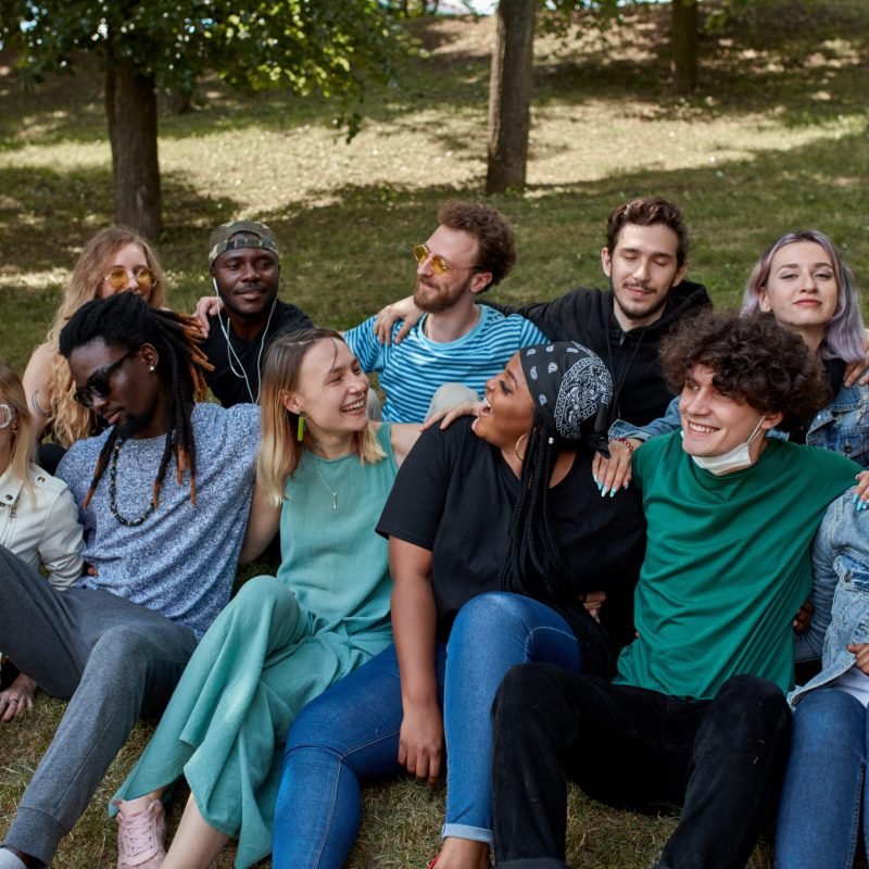 happy caucasian and african american people have rest in the public park. people urge to be tolerant of each other. friendship, people relationships